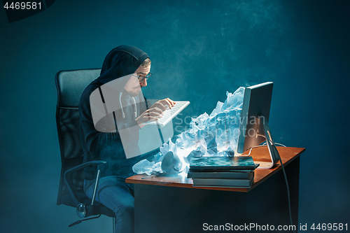 Image of Young stressed handsome businessman working at desk in modern office shouting at laptop screen and being angry about spam