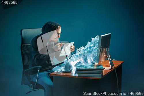 Image of Young stressed handsome businessman working at desk in modern office shouting at laptop screen and being angry about spam