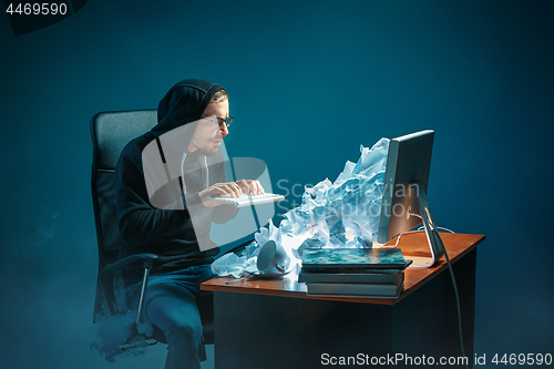 Image of Young stressed handsome businessman working at desk in modern office shouting at laptop screen and being angry about spam