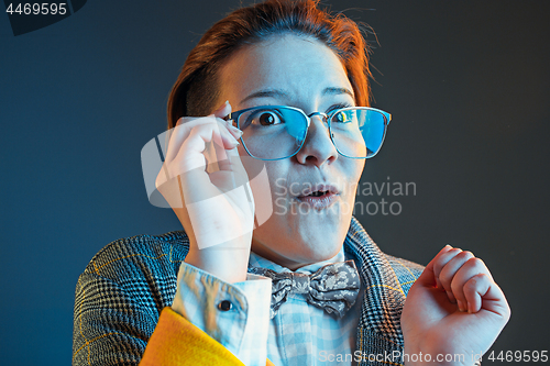 Image of The young attractive woman looking suprised isolated on dark blue