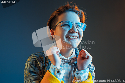 Image of The happy business woman standing and smiling against dark blue background.