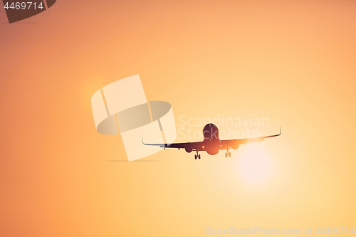 Image of Airplane landing at sunset