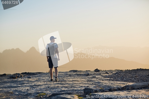 Image of Tourist in mountain at sunset