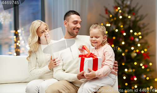 Image of happy family at home with christmas gift