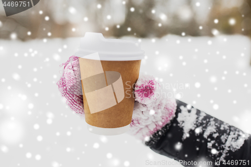 Image of close up of hand with coffee outdoors in winter