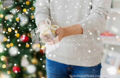 Image of close up of man with christmas gift at home