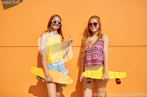 Image of teenage girls with short skateboards outdoors