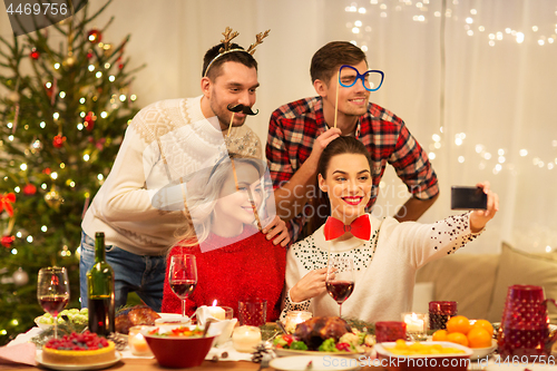 Image of friends taking selfie at christmas dinner