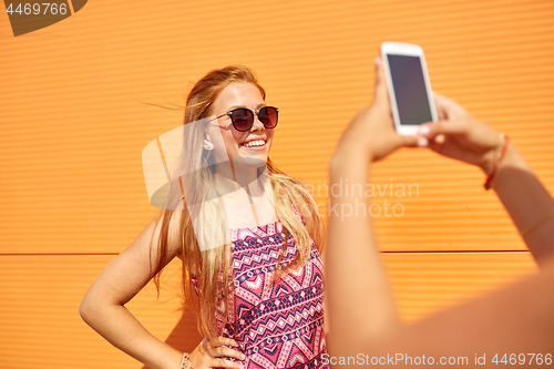 Image of teenage girl photographing friend by smartphone