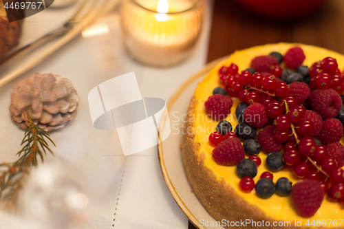 Image of close up of berry cake on christmas table at home