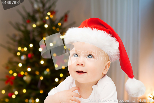 Image of close up of little baby in santa hat at christmas