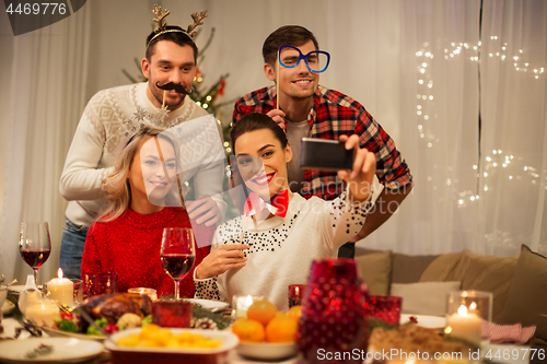 Image of friends taking selfie at christmas dinner