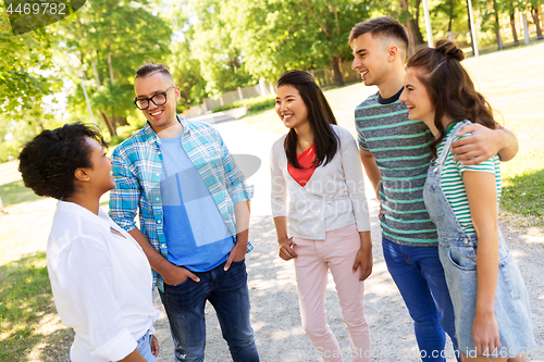 Image of happy international friends talking in park