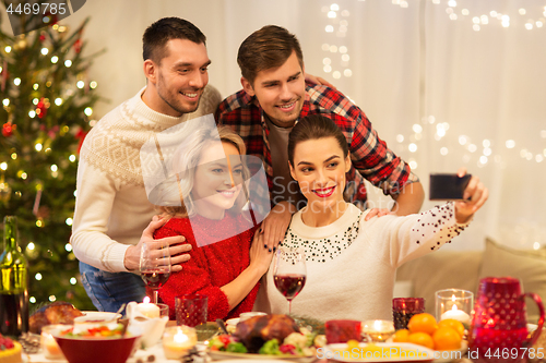 Image of friends taking selfie at christmas dinner