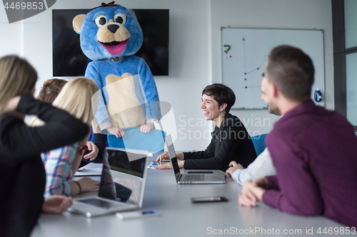 Image of boss dresed as bear having fun with business people in trendy of