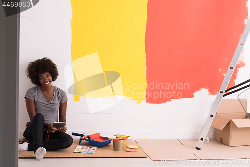 Image of back female painter sitting on floor