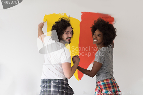 Image of multiethnic couple painting interior wall