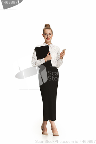 Image of Full length portrait of a smiling female teacher holding a folder isolated against white background