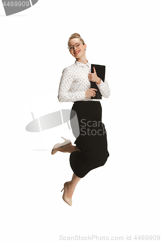 Image of Full length portrait of a smiling female teacher holding a folder jumping against white background