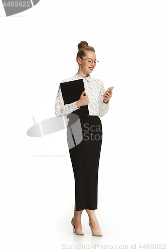 Image of Full length portrait of a smiling female teacher holding a folder isolated against white background