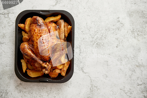 Image of Roasted chicken or turkey with potatoes in black steel mold