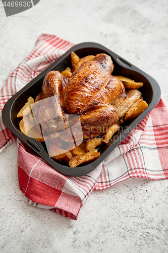 Image of Roasted chicken or turkey with potatoes in black steel mold