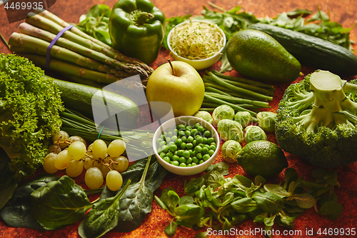 Image of Fresh green vegetables and fruits assortment placed on a rusty metal