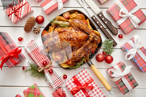 Image of Roasted whole chicken or turkey served in iron pan with Christmas decoration
