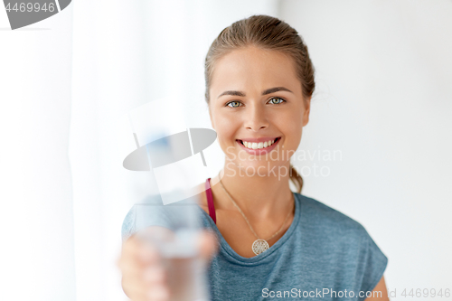 Image of happy woman showing bottle of water