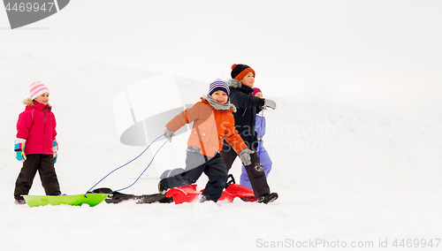 Image of happy little kids with sleds in winter