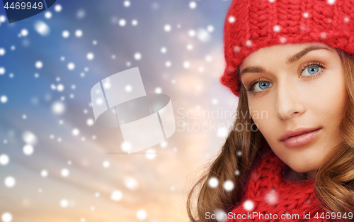 Image of woman in red hat and scarf over snow background