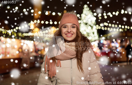 Image of happy young woman at christmas market in winter