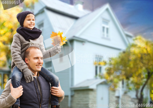 Image of father and son with autumn maple leaves over house