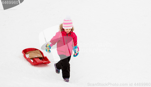 Image of little girl with sled on snow hill in winter