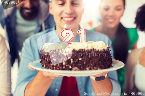 Image of man with cake and friends at birthday party