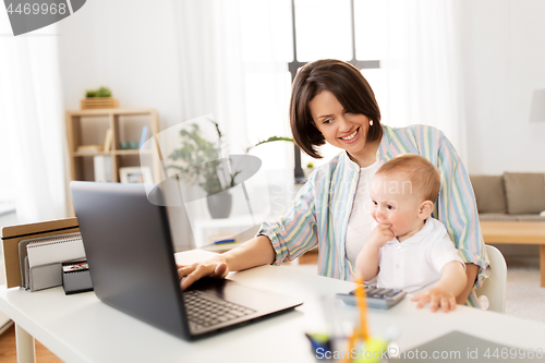Image of working mother with baby boy and laptop at home