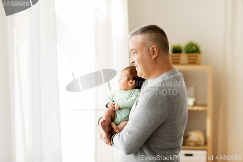 Image of happy father holding with little baby son at home