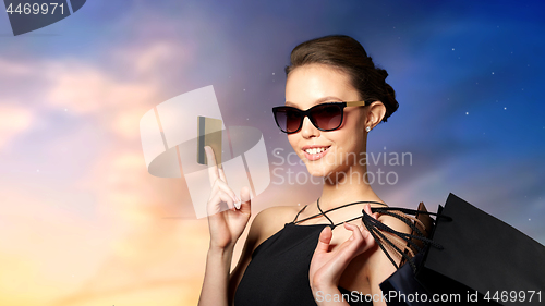 Image of happy woman with credit card and shopping bags