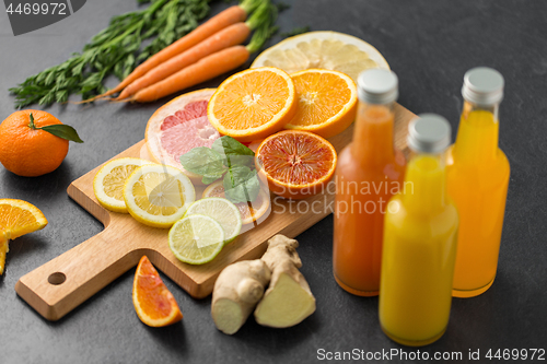 Image of glass bottles of fruit juice on slate table top