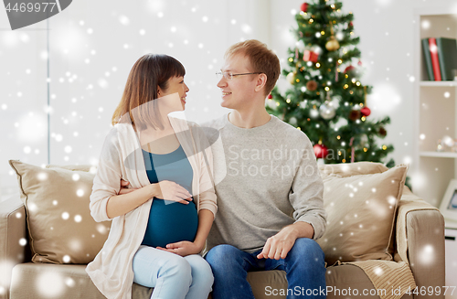 Image of pregnant wife with husband at home at christmas