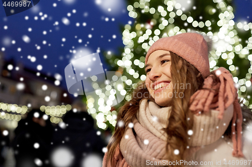 Image of happy young woman at christmas market in winter