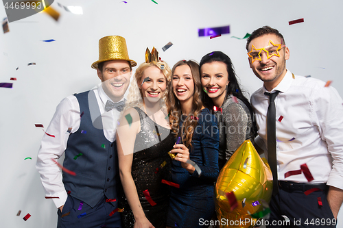 Image of friends with party props and confetti laughing