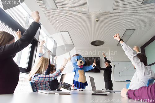 Image of boss dresed as bear having fun with business people in trendy of