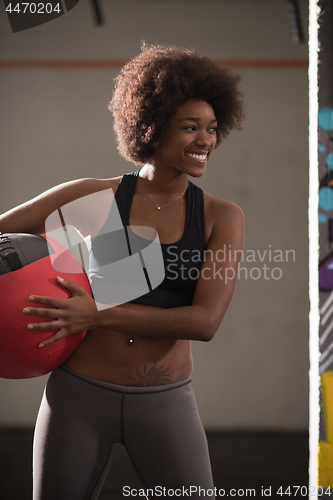 Image of black woman carrying crossfit ball