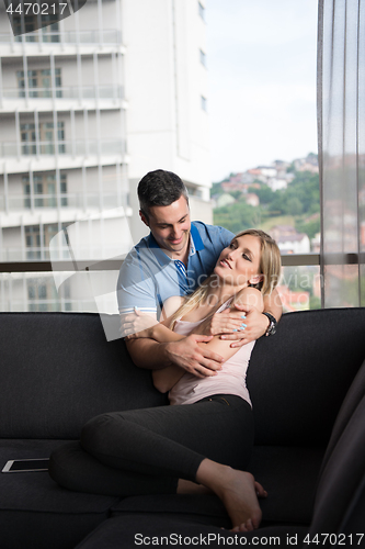 Image of young handsome couple hugging on the sofa