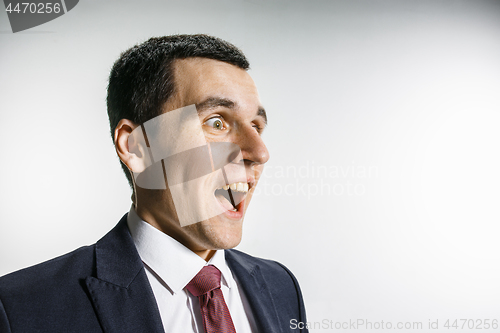 Image of Three-quarter portrait of a businessman with surprised and smiling face. Confident professional with piercing look in the foreground of the camera.