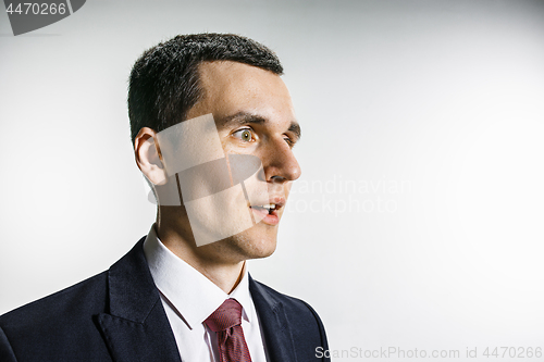 Image of Three-quarter portrait of a businessman with surprised and smiling face. Confident professional with piercing look in the foreground of the camera.