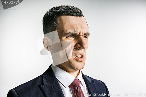 Image of Three-quarter portrait of a businessman with disgust face. Confident professional with piercing look in the foreground of the camera.