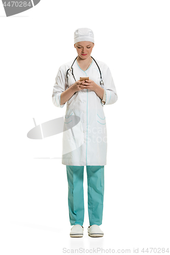 Image of Beautiful young woman in white coat posing at studio. Full length studio shot isolated on white.