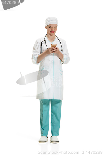 Image of Beautiful young woman in white coat posing at studio. Full length studio shot isolated on white.